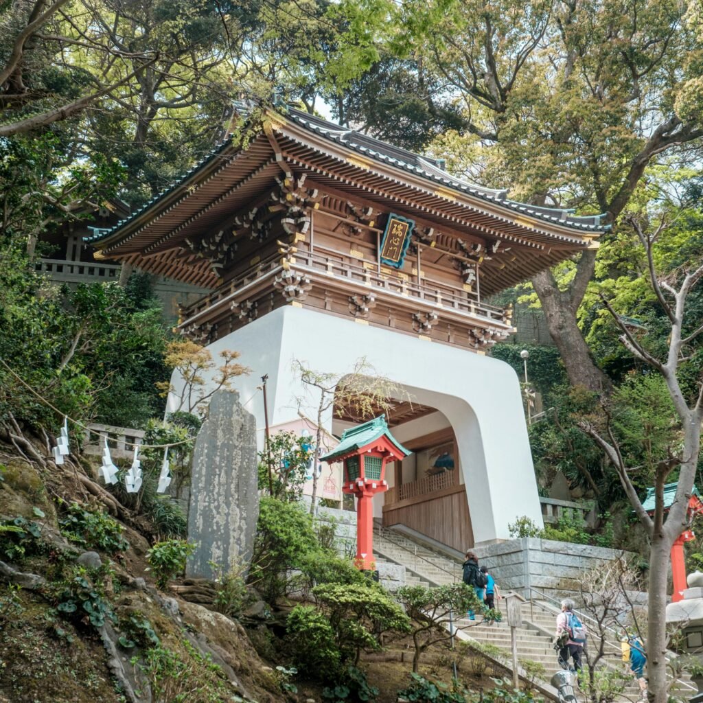 A traditional Zuishinmon gate at Enoshima Shrine, Fujisawa, surrounded by lush greenery.